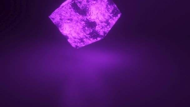 Een kubus helder gloeiende steen verbrijzelt in duizenden kleine stukjes in slow motion. Vernietigingsconcept — Stockvideo