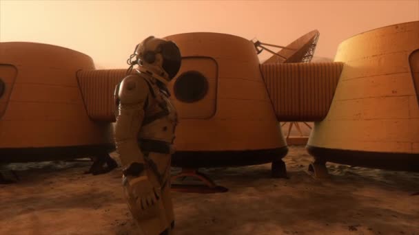 Astronot di planet Mars, membuat jalan memutar di sekitar markasnya. Astronot berjalan di sepanjang pangkalan. Badai debu kecil. Satelit piring mengirimkan data ke tanah. Animasi 3D realistis — Stok Video
