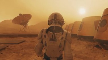 Mars gezegenindeki astronot, üssünün etrafından dolanıyor. Astronot üs boyunca yürüyor. Küçük bir toz fırtınası. Uydu anten yere veri gönderiyor. Gerçekçi 3 boyutlu animasyon