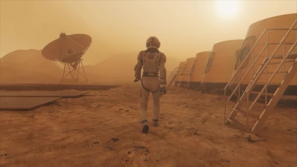 Mars gezegenindeki astronot, üssünün etrafından dolanıyor. Astronot üs boyunca yürüyor. Küçük bir toz fırtınası. Uydu anten yere veri gönderiyor. Gerçekçi 3 boyutlu animasyon — Stok video