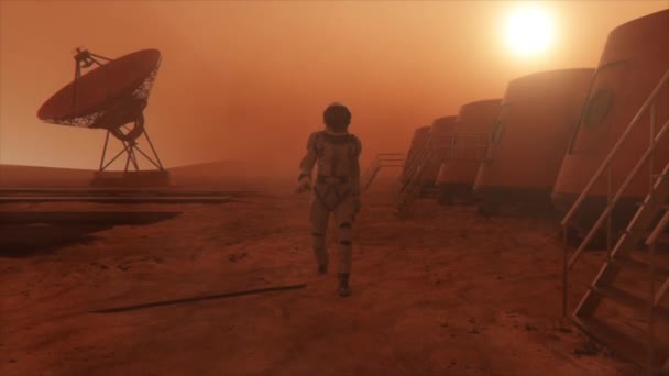 Astronaut na planetě Mars, objíždí svou základnu. Astronaut kráčí po základně. Malá prachová bouře. Satelitní anténa posílá data na zem. Realistická 3D animace — Stock video