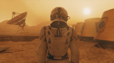 Mars gezegenindeki astronot, üssünün etrafından dolanıyor. Astronot üs boyunca yürüyor. Küçük bir toz fırtınası. Uydu anten yere veri gönderiyor. 3B illüstrasyon
