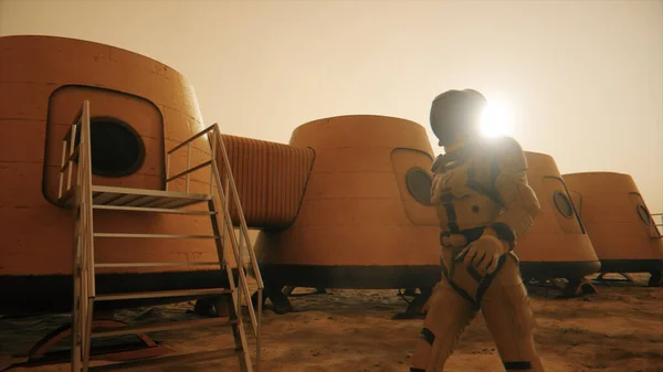 惑星火星の宇宙飛行士は 彼の基地の周りを迂回します 基地を歩いている宇宙飛行士 小さな砂嵐 衛星皿は地面にデータを送る 現実的な3Dイラスト — ストック写真