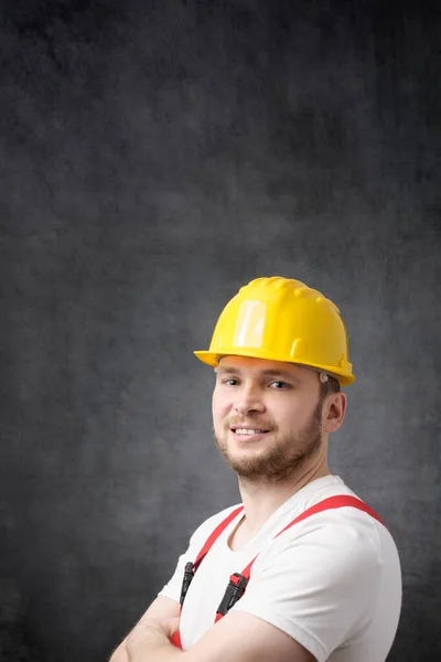 Glücklicher, lächelnder Arbeiter mit verschränkten Armen, der in die Kamera blickt Stockbild