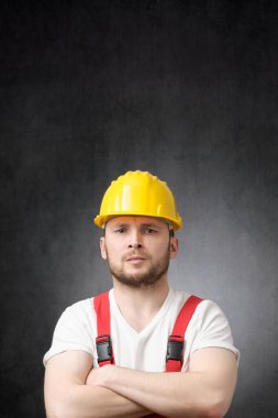 Kollarını kavuşturmuş kızgın inşaat işçisi.