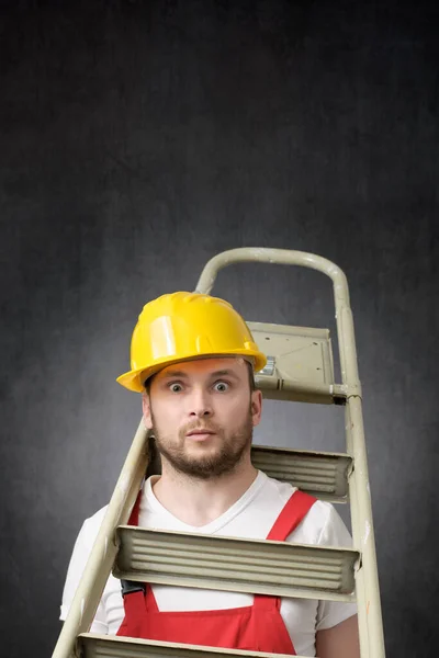 Porträt eines unbeholfenen Arbeiters mit Leiter — Stockfoto