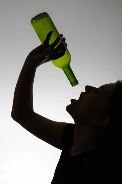 Silhouette of an alcoholic woman with a bottle — Stock Photo, Image