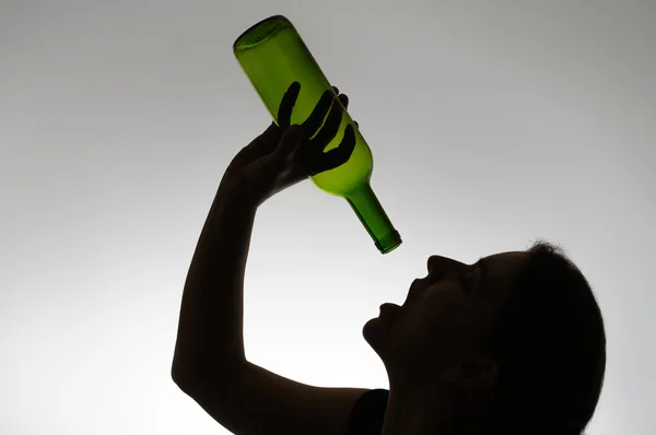 Silhouette of an alcoholic woman with a bottle — Stock Photo, Image