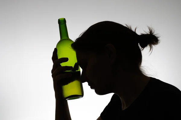 Silhouette of a woman holding a bottle — Stock Photo, Image