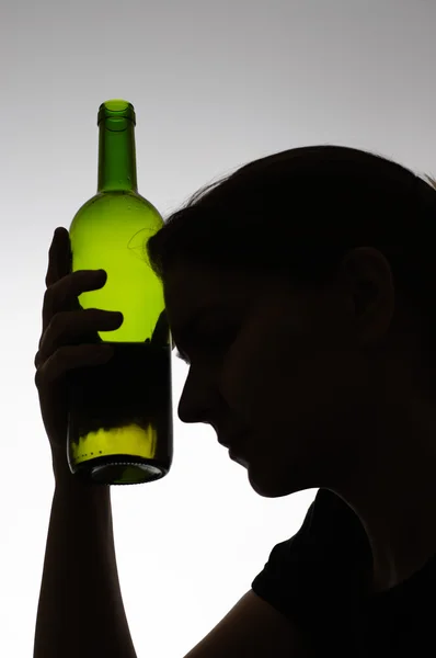 Silueta de una mujer sosteniendo una botella — Foto de Stock