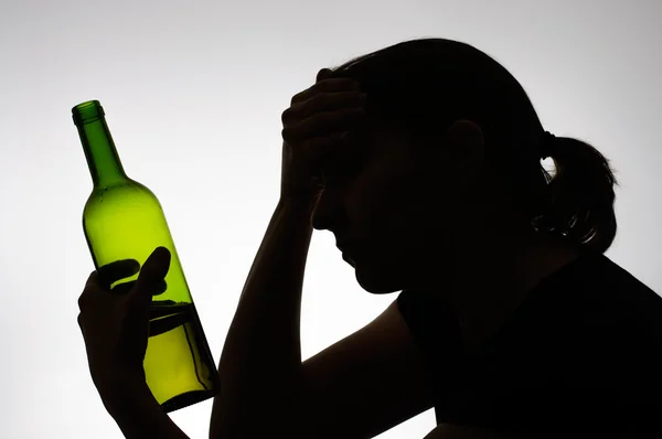 Silhouet van een vrouw met een fles — Stockfoto