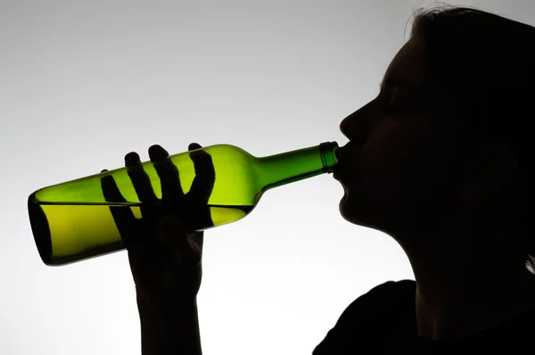 Alcoholic woman drinking from a bottle — Stock Photo, Image