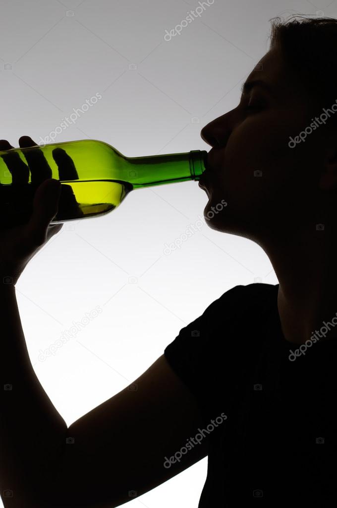 Alcoholic woman drinking from a bottle