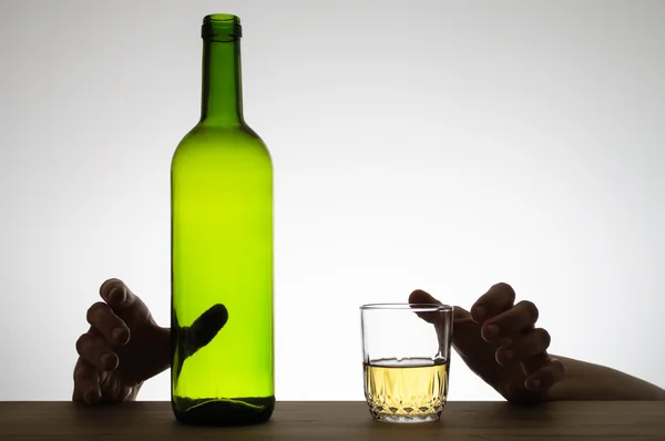 Руки тянутся за стаканом и бутылкой — стоковое фото