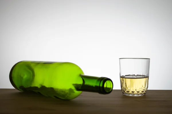Bottiglia di vino e un bicchiere di vino su un tavolo — Foto Stock