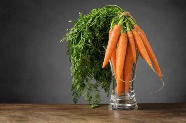 Fresh carrots in a glass vase — Stock Photo, Image