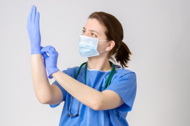 Mavi cerrahi eldiven koyarak doktor