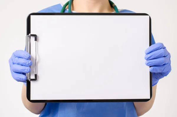 Doctor showing blank clipboard — Stock Photo, Image