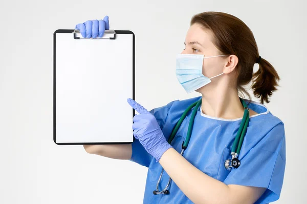 Doctor pointing at blank clipboard — Stock Photo, Image