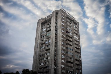 Sırbistan 'ın başkenti Belgrad' daki Novi Beograd 'dan gelen yüksek binadaki seçici bulanıklık, arka planda hareketli bir gökyüzü etkisiyle barbarca bir tarzla geleneksel komünist yerleşim yeri.