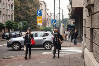 BELGRAD, SERBIA - 24 Ekim 2020: Kadınlar, genç kızlar ve yaşlı kadınlar, Coronavirus Covid 19 krizinde yüz maskesi koruyucu donanım takarak sosyal mesafeyi kullanarak yürüyorlar