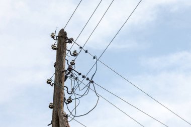 Elektrik kaynağı kablosu ve seramik yalıtkanları olan eski elektrik, güneşli bir öğleden sonra kamu elektrik ağıyla eski bir bağlantı sisteminden yapılmış.