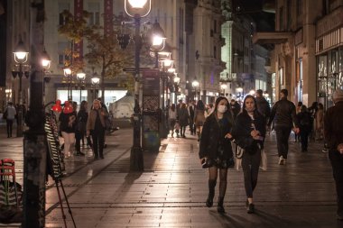 BELGRAD, SERBIA - 27 Ekim 2020: Genç insanlar ve iki genç kız, arkadaşlar, Coronavirus Covid 19 krizinde yüz maskesi koruyucu ekipman takarak gece yürüyorlar