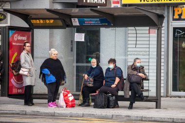 BELGRAD, SERBIA - 17 Ekim 2020: Coronavirus covid 19 krizi sırasında Belgrad 'ın otobüs durağında araç bekleyen solunum maskesi takan yaşlı kadın