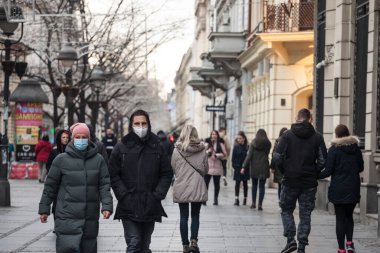 BELGRAD, SERBIA - 12 Aralık 2020: Kışın Belgrad 'ın Kneza Mihailova caddesinde Coronavirus covid 19 krizinde solunum maskesi takan çift