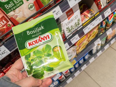 BELGRAD, SERBIA - 19 HAZİRAN 2021: bir torba Kotany fesleğeni yaprağı tutan eller. Kotanyi, baharat, baharat ve baharat üreten Avusturyalı bir gıda endüstrisi şirketidir.