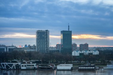 BELGRAD, SERBIA - 1 Ocak 2021: Splav 'ın önündeki Usce' nin alışveriş ve iş merkezinin gökdelen kuleleri. Splavovi, yüzen kulüp barları ve restoranlar olarak kullanılan tipik sal botlarıdır.
