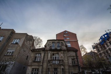 Belgrad, Sırbistan 'ın gelişmekte olan bir bölgesinde, bazıları inşaat halinde olan çağdaş kulelerle çevrili eski, ihmal edilmiş ve çürüyen konut binaları