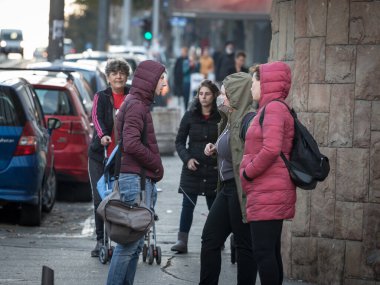 BELGRAD, SERBIA - NOVEMBER 1, 2020: Arkadaş grubunda seçici bulanıklık, genç yetişkinler, erkekler ve kadınlar, sosyalleşme, yüz maskesi takanlar, diğerleri takmayanlar, koronavirüs kovid 19 krizi