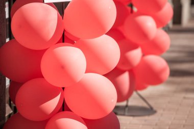 Bir sürü şişme balon, kırmızı kauçuk balonlar, şişirilmiş, açık havada bir fotoğraf olarak sergileniyor, neşeli bir kutlama sırasında.