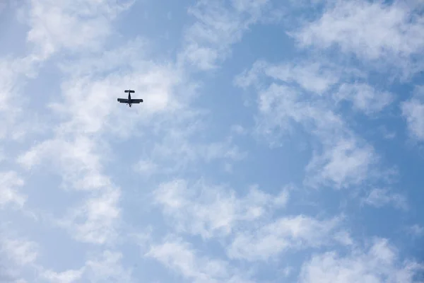 Old retro plane, a  vintage biplane with turbopropellers, flying, small, with a blue sky sunny background. It is a symbol of the beginning of aviation