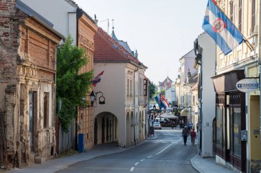 VUKOVAR, CROATIA - 11 Mayıs 2018: Franjo Tudjman caddesi, Hırvatistan 'ın kuzeyindeki Slavonya kenti Vukovar' ın ana caddesi, güneşli bir günde ikonik binalarıyla