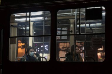 BELGRAD, SERBIA - 13 Ekim 2020: Tramvaydaki yolcularda seçici bulanıklık, biri solunum maskesi takıyor, diğeri toplu taşımada, Coronavirus covid 19 sağlık krizi üzerinde değil