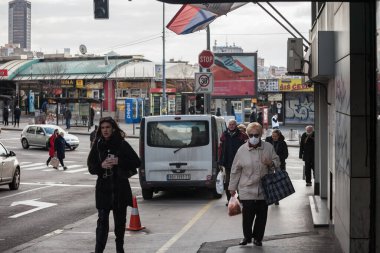BELGRAD, SERBIA - 6 Mart 2021 Coronavirus covid 19 sağlık krizi sırasında takmayan genç bir kızın yanında solunum maskesi takan yaşlı bir kadın