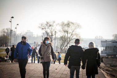 BELGRAD, SERBIA - 13 Mart 2021: Koronavirüs kovid 19 sağlık krizi sırasında Belgrad 'ın bir caddesinde yüz maskesi takan bir erkek ve bir kadın üzerinde seçici bulanıklık