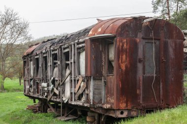 Eski ve paslı bir yolcu vagonu, bir vagon kayıp ve kapalı bir tren istasyonunda çürümeye bırakılmış.