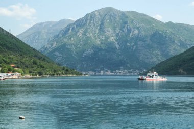 Öğleden sonra Adriyatik Denizi 'nin sularında Kotor Körfezi veya Kotorska Boka kıyıları arasında araba taşıyan feribot. Kotor körfezi Karadağ 'ın en ikonik simgelerinden biri.