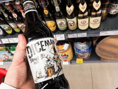 BELGRAD, SERBIA - 12 Mayıs 2021: Wychwood tarafından üretilen bir şişe Diceman birası tutan eller. Wychwood bira fabrikası çeşitli bira üreten bir İngiliz bira fabrikasıdır.