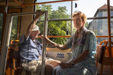 BUDAPEST, HUNGARY - 11 AĞUSTOS 2017: Yaşlı insanlar, aşıklar, kıdemli çiftler, Budapeşte toplu taşıma sisteminin bir tramvayında oturuyorlar, ya da ana ulaşım seçeneklerinden biri olan BKV kötü adamları,.