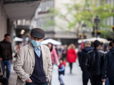 BELGRAD, SERBIA - 3 Mayıs 2021: Belgrad 'da Kneza Mihaila caddesinde Coronavirus covid 19 sağlık krizi sırasında solunum maskesi takan yaşlı adam