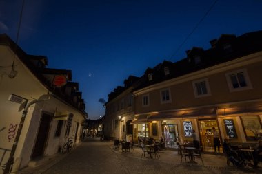 LJUBLJANA, SLOVENIA - 14 Haziran 2021: Geceleri Trubarjeva cesta caddesinde seçici bulanıklık ve yakınlardaki bir bar kafeteryası. Trubarjeva, Ljubljana 'nın ana yaya sokağıdır..