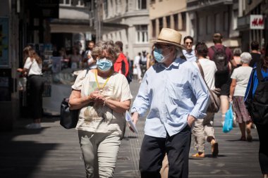 LJUBLJANA, SLOVENIA - 15 Haziran 2021: Yaşlı erkek ve kadın, çift, maske takıyor, Coronavirus covid 19 krizi sırasında Ljubljana caddesinde uyanıyorlar