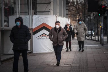 BELGRAD, SERBIA - 14 Şubat 2021: Coronavirus Covid 19 krizinde maske takan Asyalı orta yaşlı bir adam için seçici bulanıklık