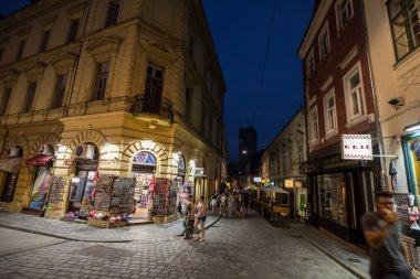 ZAGREB, CROATIA - JUNE 19, 2021: Radiceva ulica street at night, with people passing by with speed blur in fornt of boutiques and souvenirs shops. It is a street of the city center, in gornji Grad. clipart