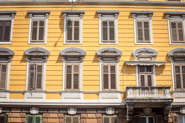 在伊斯特利亚地区的一座古老的老房子上 一座带有传统欧洲木制百叶窗和阳台的黄色住宅建筑的典型意大利冥想式立面 — 图库照片