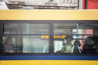 BELGRAD, SERBIA - 1 Haziran 2021: Coronavirus covid 19 sağlık krizi sırasında toplu taşımada GSP Beograd otobüsünün vitrininde solunum maskesi takan genç kadın